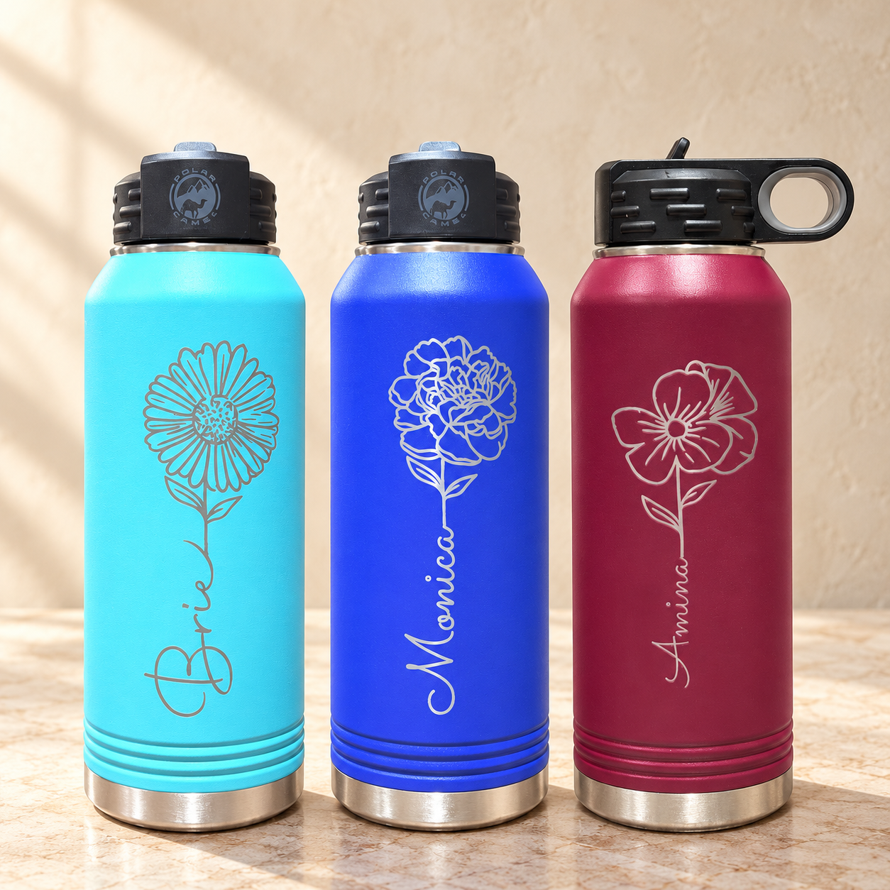 Birth flower engraved water bottles in turquoise, royal blue and burgundy on a…